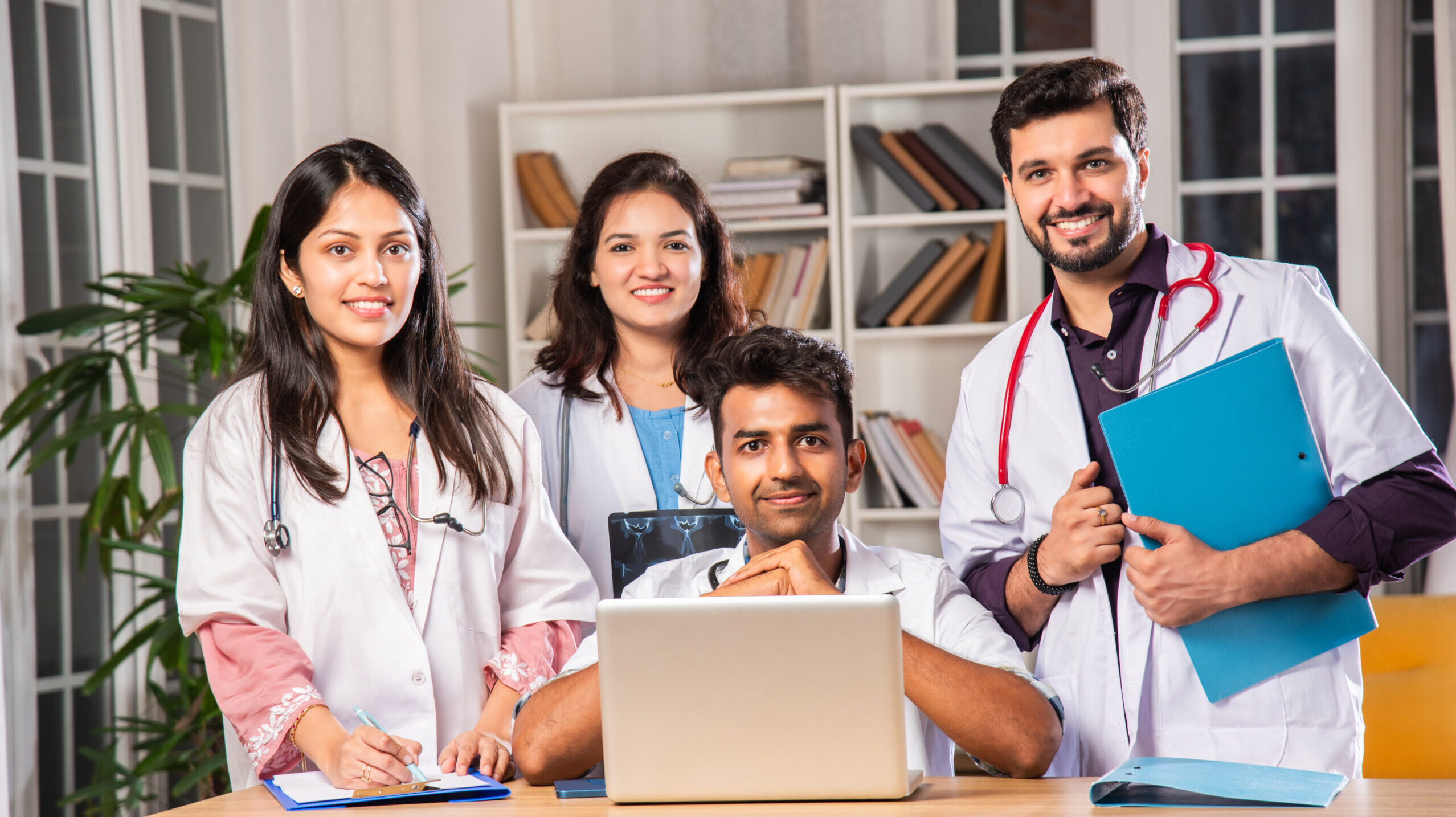 Group of medical students smiling confidently while studying together indoors