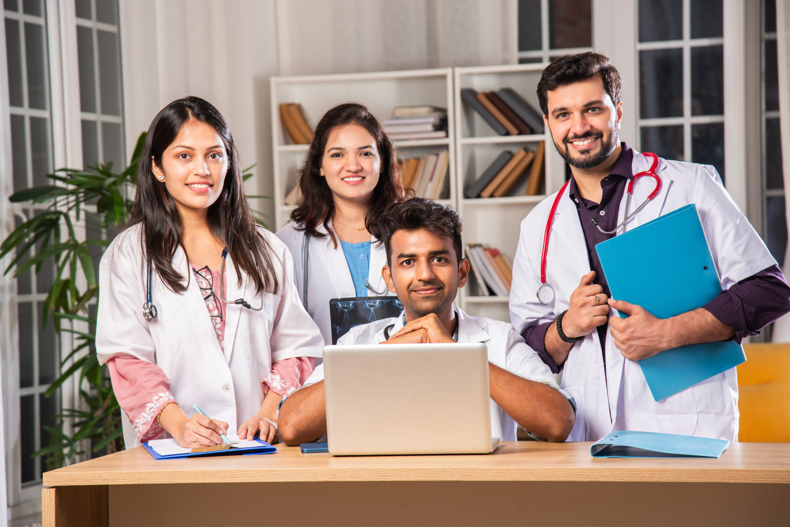 Group of medical students smiling confidently while studying together indoors